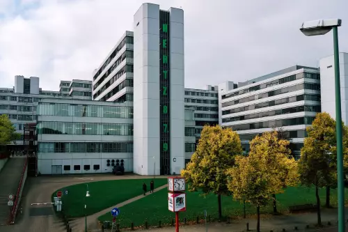 Blick auf die Universität Bielefeld. Der auf einem der Gebäude senkrecht ausgerichtete, grünfarbige Schriftzug 'Hertz 87.9' verweist auf das Campus-Radio mit seiner UKW-Frequenz.