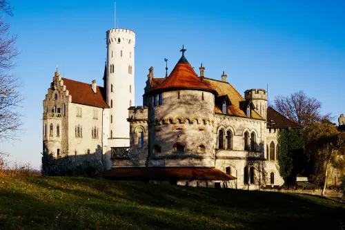 Blick auf das Schloss Lichtenstein am Albtrauf bei Honau mit seinem massiven Mauerwerk und seinen roten Dachziegeln.