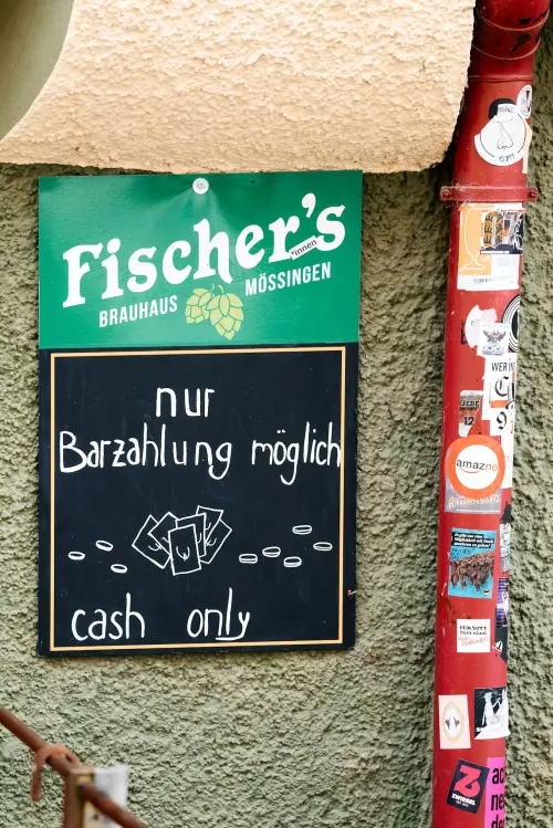 Eine Tafel an der Hauswand der Kneipe "Storchen" in Tübingen, auf der zu lesen ist: "nur Barzahlung möglich - cash only".