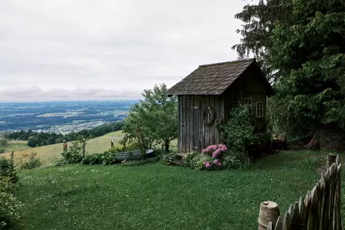 Kleine Gartenhütte neben einem hochgelegenen Spazierweg in Eichenberg, Österreich und Blick auf die deutsche Seite vom Bodensee.