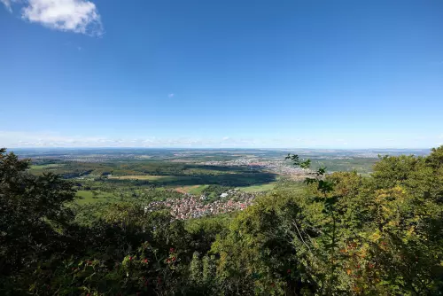 Blick vom Wanderweg, der sich um das obere Speicherbecken des Pumpspeicherwerks Glems windet, auf die Ortschaft Glems im Tal.