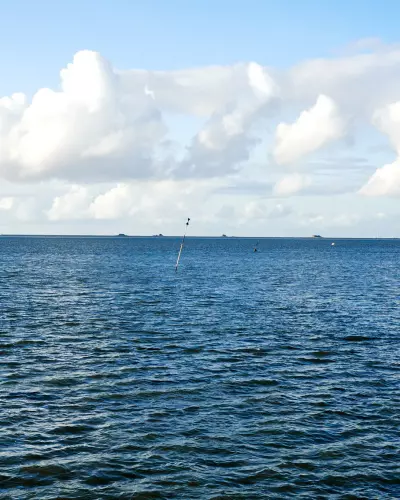 Blick auf die "blanke", bläuliche Nordsee an einem wolkigen, aber sonnigen Tag.