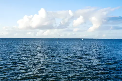 Blick auf die "blanke", bläuliche Nordsee an einem wolkigen, aber sonnigen Tag.