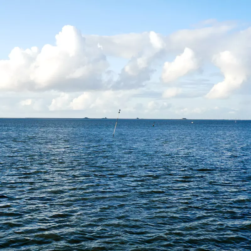 Blick auf die "blanke", bläuliche Nordsee an einem wolkigen, aber sonnigen Tag.
