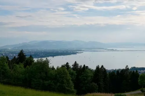 Blick von einem Wanderweg um Eichenberg, Österreich aus, in Richtung Bregenz am Bodensee, an einem bewölkten Tag im Mai.