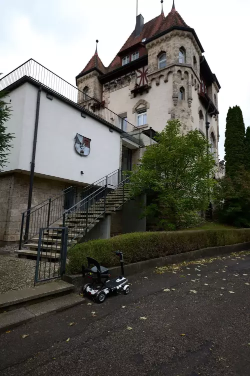 Elektrisch betriebenes "Seniorenmobil" am Straßenrand vor einer Burschenschaft in Tübingen geparkt.