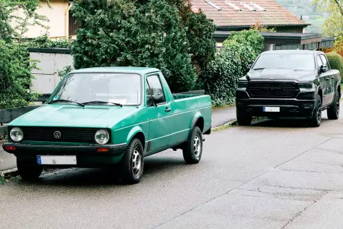 Parkend am Straßenrand; Der VW Caddy wirkt wie ein praktischer, kleiner Transporter; Der Dodge Ram hingegen wie sein grobschlächtiger, zu groß geratener Bruder.