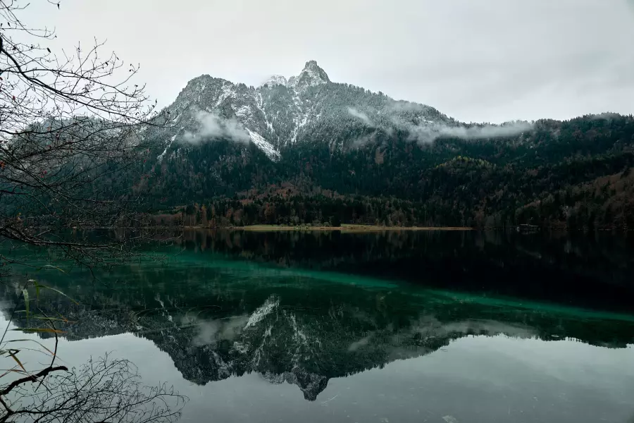 Kodacolor-Noritsu-Version - Blick vom Rundwanderweg Alpsee auf den am Gipfel leicht verschneiten Gassenthomaskopf, der sich in der grünlichen, ganz ruhigen Seeoberfläche spiegelt.
