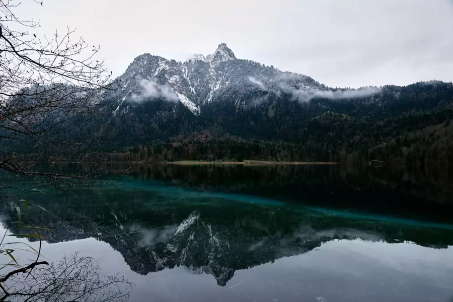 Kodacolor-Frontier-Version - Blick vom Rundwanderweg Alpsee auf den am Gipfel leicht verschneiten Gassenthomaskopf, der sich in der grünlichen, ganz ruhigen Seeoberfläche spiegelt.